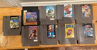 Nine NES game cartridges arranged facing forward showing front labels including Super Mario Bros 3, Teenage Mutant Ninja Turtles, Power Blade, and more.
