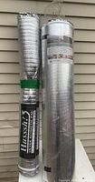 Two large unopened rolls of under floor sound barrier membrane wrapped in reflective silver material, one labeled Hussis Silver Acoustic Pad.