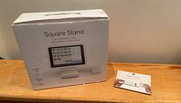 Box of Square Stand showing front with product image and text indicating it supports contactless and chip payments.