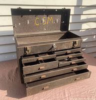 Open angled view of the steel machinists tool chest showing multiple open drawers of various sizes and the top hinged lid open, with visible interior marked "C.5M."
