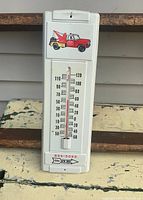 Front view of thermometer showing temperature scale and tow truck illustration