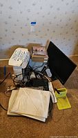 View of all electronics including computer tower, monitor, scanner, cables and adapters stacked on the floor.