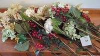 Full view of the 33 faux poinsettia and floral branches including red berries, cream and gold poinsettia, white hydrangeas and green leaves on wooden surface.