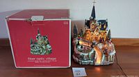 Photo of fiber optic village decoration next to original red box showing the product and packaging