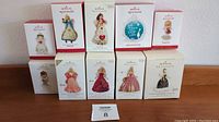 Front display of 10 Hallmark Keepsake Christmas ornaments in original boxes, including Barbie-themed and angels.