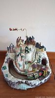Front view of the 13 inch Christmas village with train and Santa spinning overhead