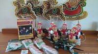Wooden Santa and reindeer decorations with six penguin figure string lights and two sets of packaged string lights including Snoopy and peppermint candy designs.