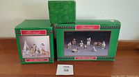 Boxes of three Native American nativity sets, green packaging with red and white labels, showing the contents illustrated on the box fronts.