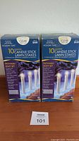 Front view of two boxes of Holiday Time 10 Lighted Candlestick Lawn Stakes, Pathway Light Set, clear color, $9.88 each.