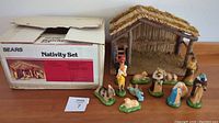 Photo showing the full set including the stable, figurines arranged in front, and the original Sears box.