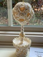 Full view of off-white carved puzzle ball and stand showing overall design and condition