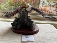 Front view of eagle figurine on wooden base