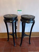 Full view of the pair of black lacquered pedestals showing shape, legs and height