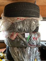 Stack of four wrapped tires showing tread pattern and overall condition