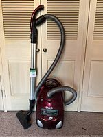 Full view of the red Shark Professional Canister Vacuum with hose and wand attachment.