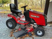 Left side profile showing mower deck, grass chute, seat and rear wheel