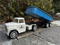 Three-quarter front view of white Ertl cab with attached blue dump trailer