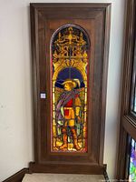 Full view of stained glass window mounted in wood case
