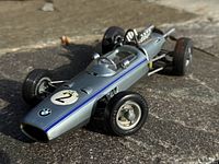 Front side angle showing blue stripe, number 2 decal, BMW logo and front wheels of the metallic silver wind-up car.