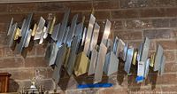 Full view of abstract geometric metal wall sculpture mounted on brick wall