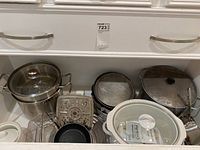 Photo showing multiple pots, pans, glass lid, steamer insert, and white crock pot