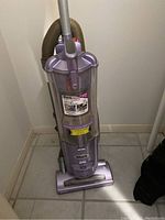 Full view of purple Shark Navigator upright vacuum with dust container and hose attached.