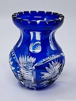 Full view of deep cobalt blue crystal vase showing scalloped rim and cut crystal floral/starburst designs