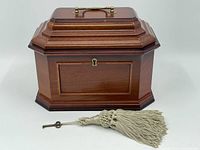 Front view of the box with visible lock and key with tassel placed in front.