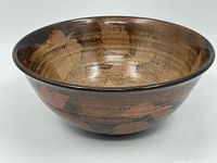 Side angled view of the ceramic bowl showing the leaf motif and glossy glaze.