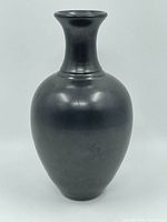 Front view of the black ceramic vase showing shape and finish