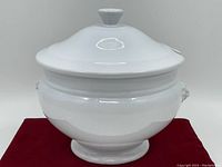 Front view of white ceramic covered dish with lid and knob handle.