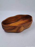 Side view of the handmade wood bowl showing the smooth inner surface and natural grain patterns.