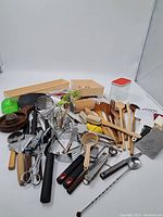 Wide view of the entire lot showing all utensils and tools spread out on a white background.
