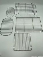 Top-down view of all five baking and cooling racks arranged on a plain surface showing different shapes and sizes