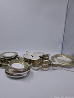Full set of Mikasa Rosemont bone china dishes including plates, cups, and saucers with decorative gold and floral trim.