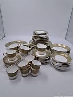 Full set of Mikasa Rosemont dishes including stacked plates, cups, and saucers arranged on white background.