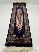 Full view of the small rectangular rug showing overall design and color composition with cream fringes on edges.