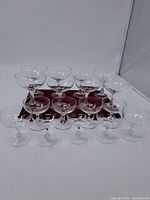Front view showing all 14 pieces of clear glass stemware arranged in two rows on a plain surface with a white background.