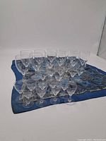 Full set of 27 stemware pieces arranged on a patterned cloth showing six rows of glasses with three distinct sizes.