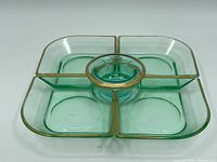 Top view of the assembled platter set showing four square dishes surrounding a round central dish, all with gold trim on edges.