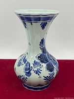 Front view of the vintage blue and white ceramic vase showing the floral pattern and flared rim.