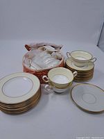 Overview of the whole dish set including cups, plates, saucers, and ornate porcelain basket