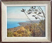 Framed oil on board painting showing a scenic view of autumn trees and blue water.