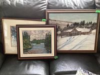 Overview of three framed artworks displayed on a sofa, showing relative sizes and frame styles