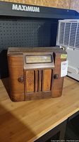 Front view of vintage wooden Rogers Majestic radio showing wooden cabinet, dial window, and front grille with control knobs.
