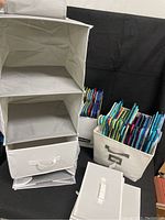 Photo showing six-drawer hanging closet organizer, collapsible fabric bins, and plastic hangers inside bins