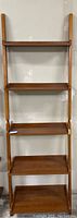 Full view of assembled leaning ladder shelf showing its five wooden shelves and two-piece construction.