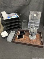 Overview showing black multi-tier organizer with whiteboard markers and eraser, clear acrylic stands, tacking paper organizers, metallic mesh drawer organizers, business card holders, candy dispenser, and brown woven leather tray.