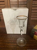Single Mikasa Jamestown crystal candle holder with gold trim displayed with original box standing behind on wooden surface.
