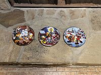 Three Garfield Christmas collector plates displayed showing different festive scenes